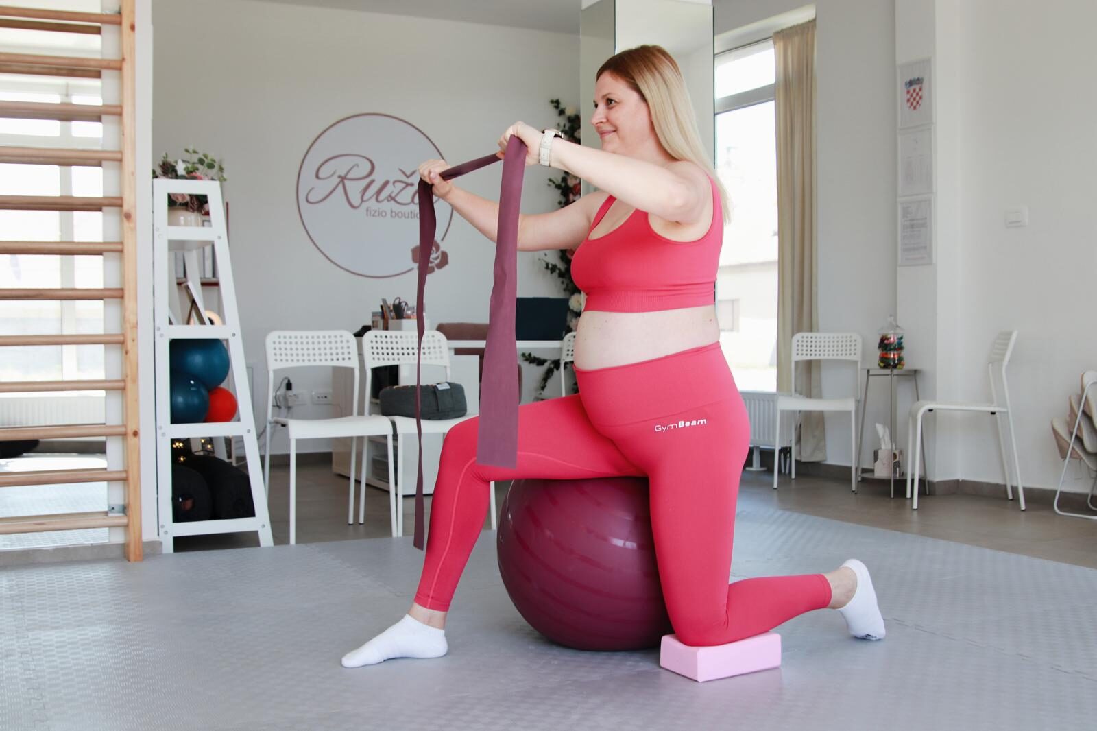 Trudnica vježba na pilates lopti s elastičnom trakom