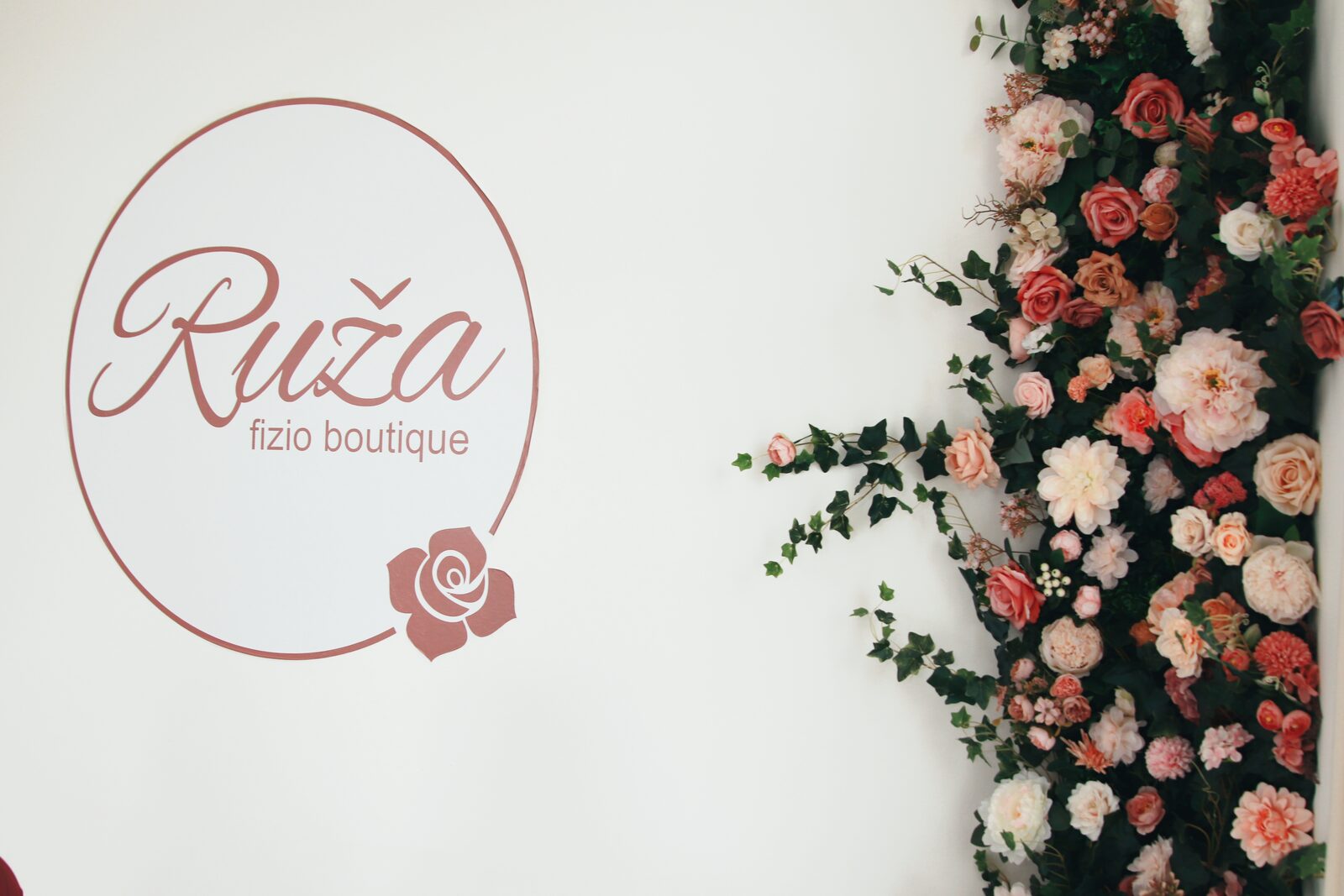 Cvjetni zid s ružama i logo Ruža fizio boutique